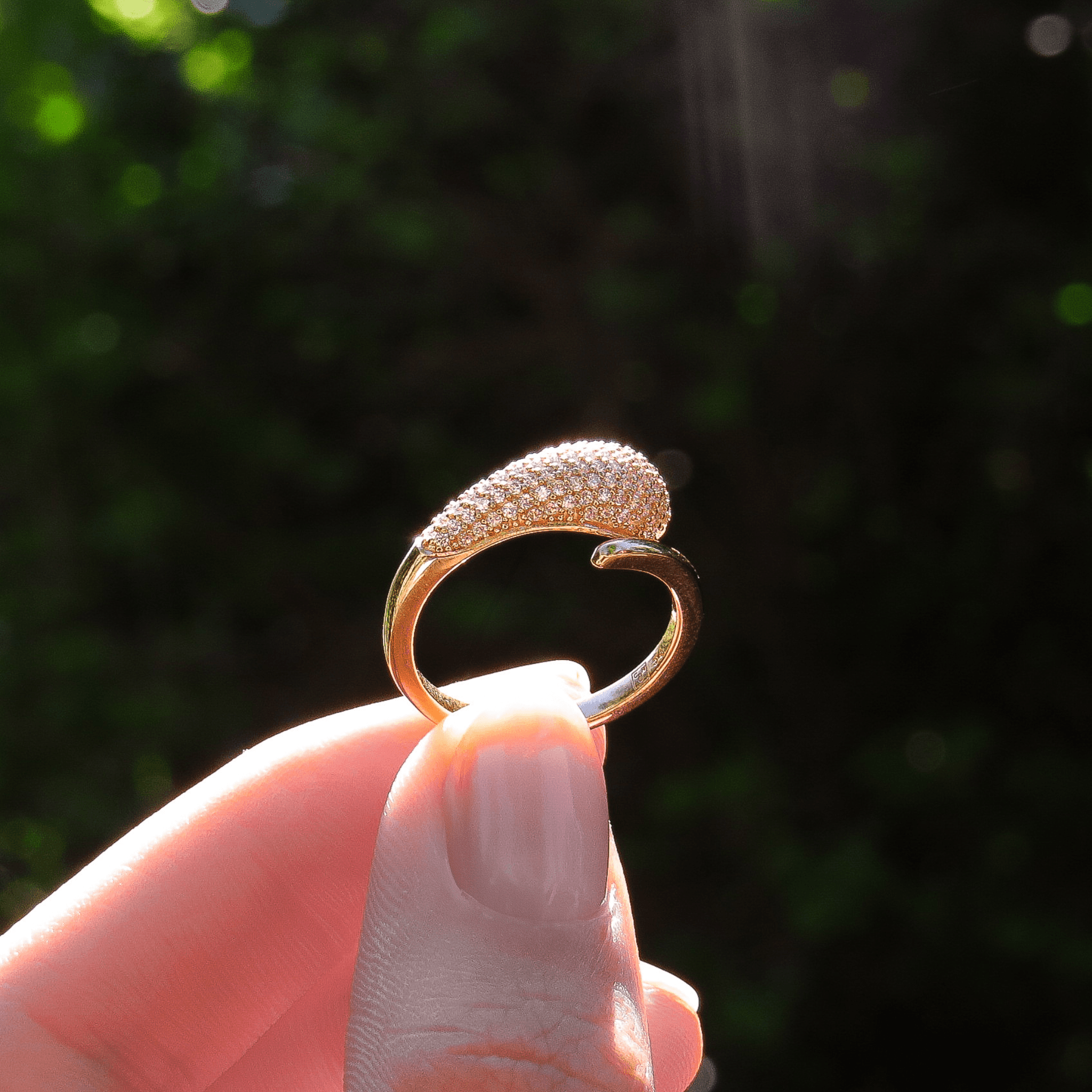 bague en plaqué or 18 carats pavée d’oxydes de zirconium blancs, design ouvert, tenue entre deux doigts en lumière naturelle