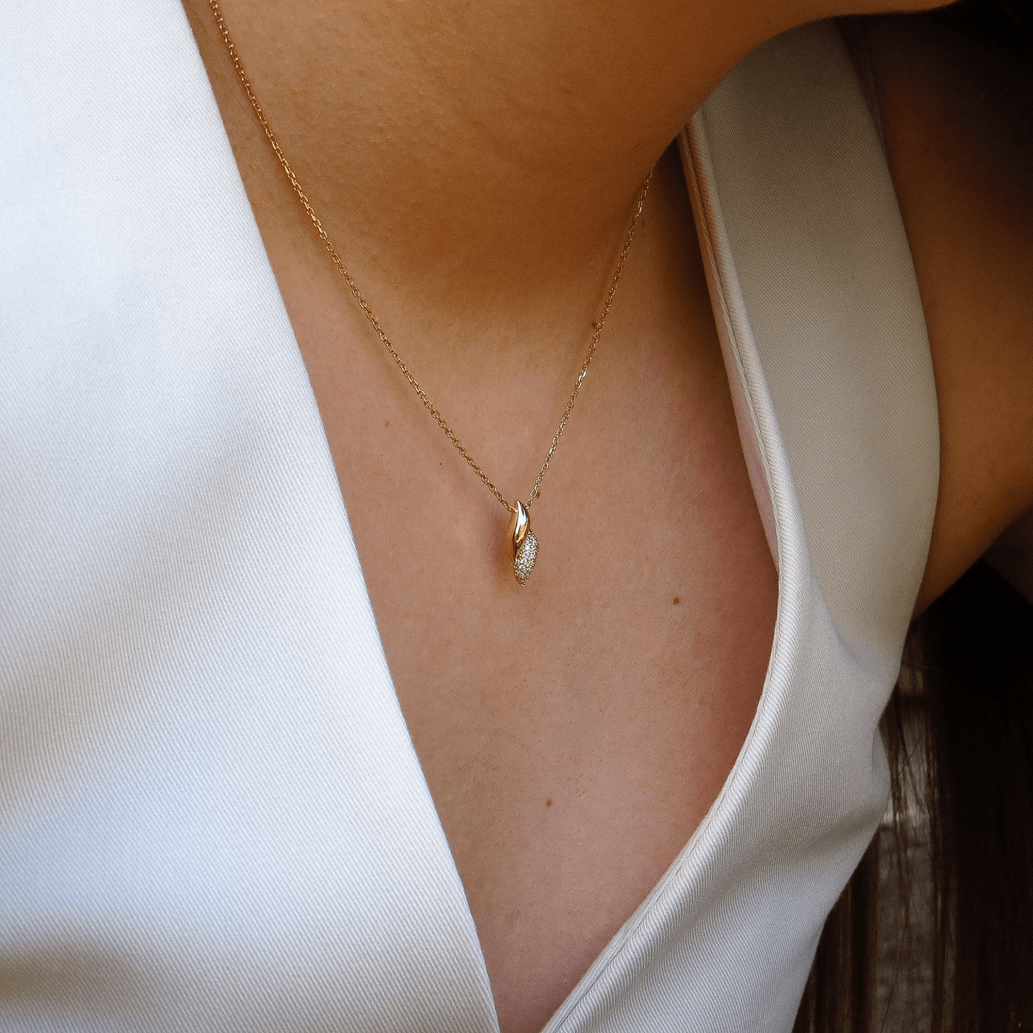Collier pendentif moderne en plaqué or 18 carats, porté avec un top blanc échancré