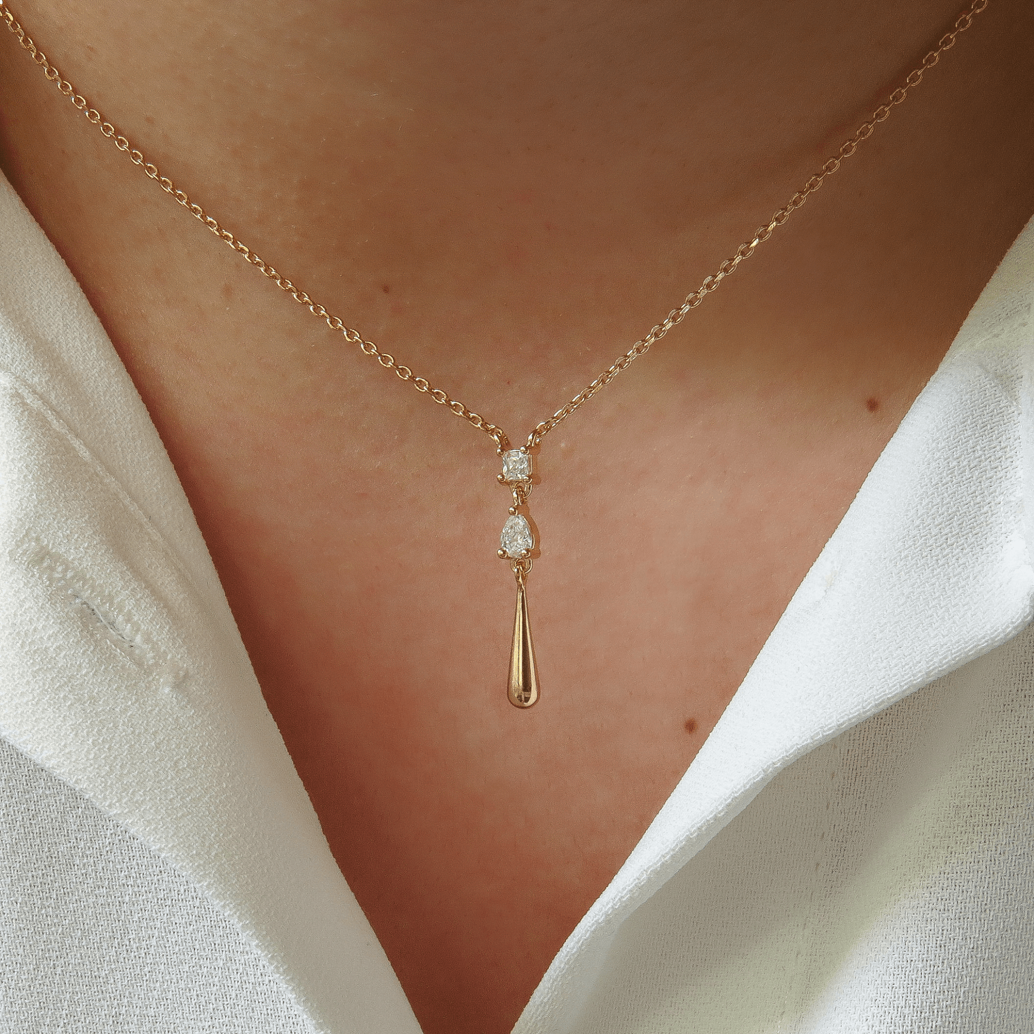 Collier en plaqué or 18 carats avec pendentif goutte et zircons, porté en gros plan