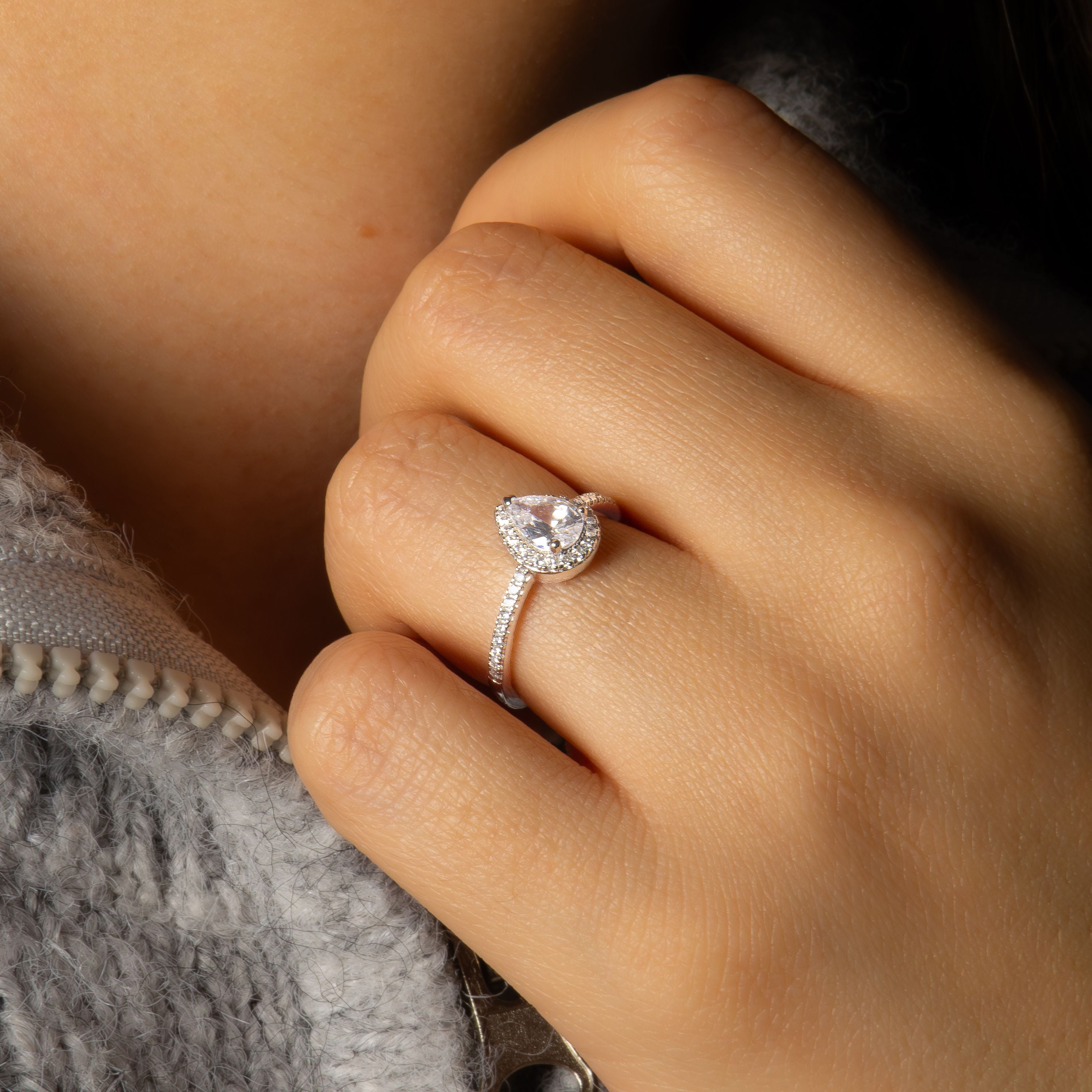 bague argent 925 forme poire avec oxydes de zirconium portée sur une main devant un pull beige
